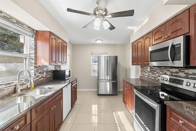 a kitchen with stainless steel appliances granite countertop a sink stove and refrigerator