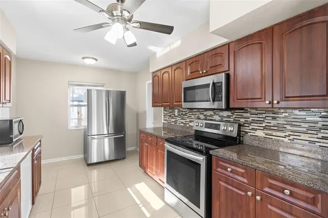 a kitchen with stainless steel appliances granite countertop a stove microwave and refrigerator