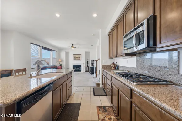 a kitchen with stainless steel appliances granite countertop a sink stove and cabinets
