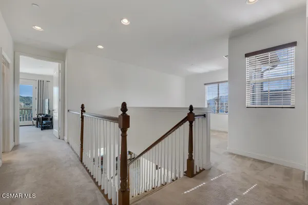 a view of a hallway with windows and stairs