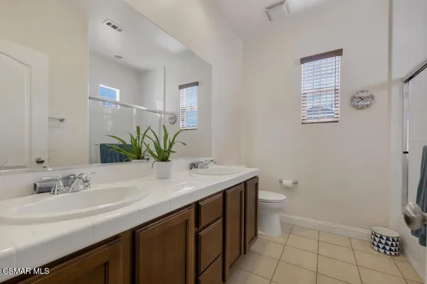 a bathroom with a granite countertop sink a toilet and a mirror