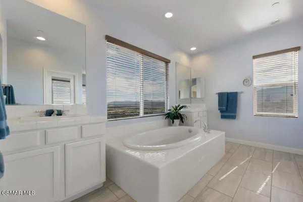a spacious bathroom with sinks mirror and bathtub