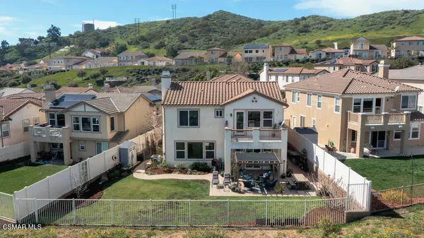 an aerial view of residential houses with outdoor space and trees