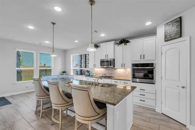 a living room with furniture kitchen view and a wooden floor