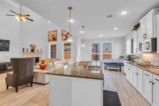 a kitchen with stainless steel appliances granite countertop a sink stove and cabinets