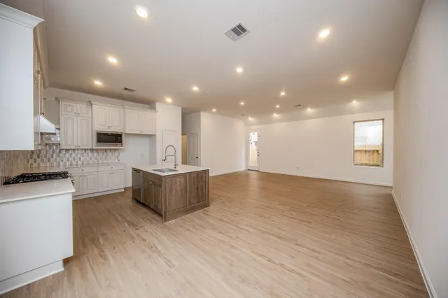a kitchen with granite countertop a stove and a sink