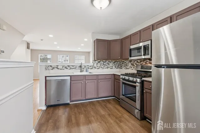 a kitchen with stainless steel appliances granite countertop a refrigerator stove a sink and a microwave