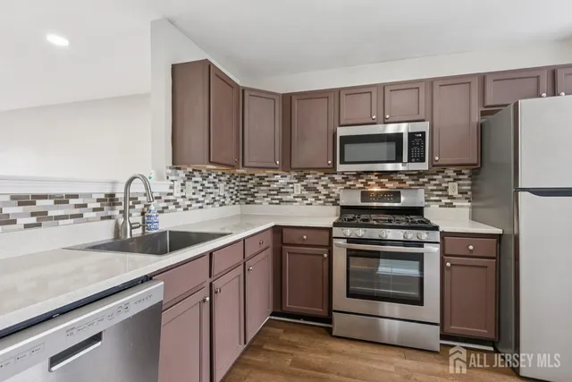 a kitchen with sink a microwave and refrigerator