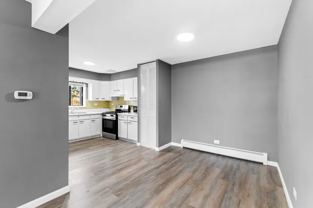a view of a kitchen with wooden floor and electronic appliances