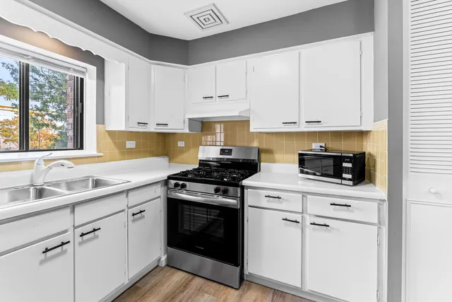 a kitchen with white cabinets and appliances