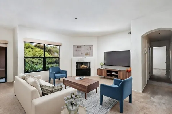 a living room with furniture a fireplace and a flat screen tv