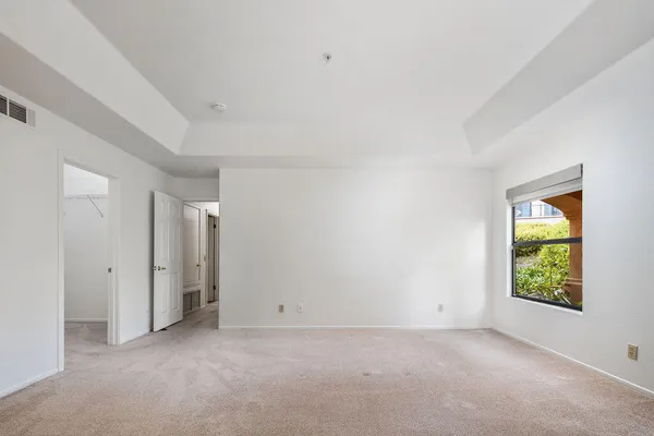an empty room with windows and closet