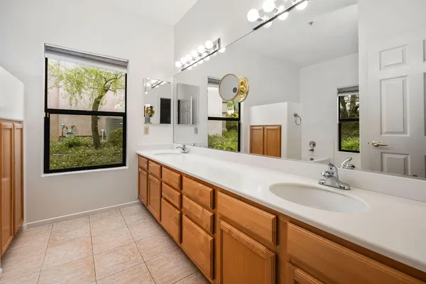 a bathroom with a double vanity sink a mirror and a bathtub