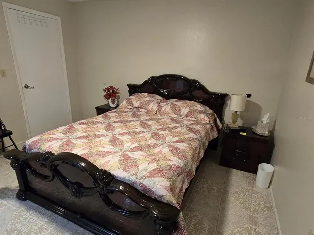 a bedroom with a bed and a lamp on dresser