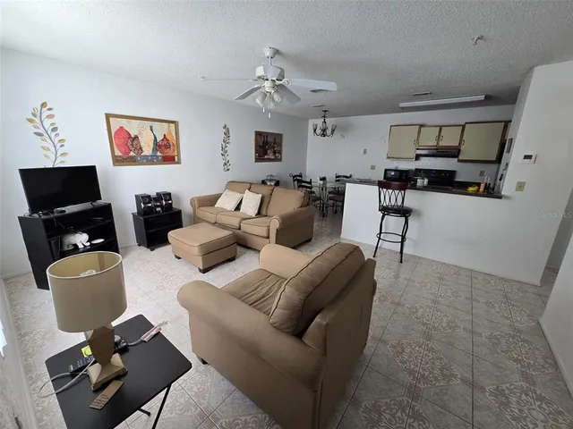 a living room with furniture a large window and a flat screen tv