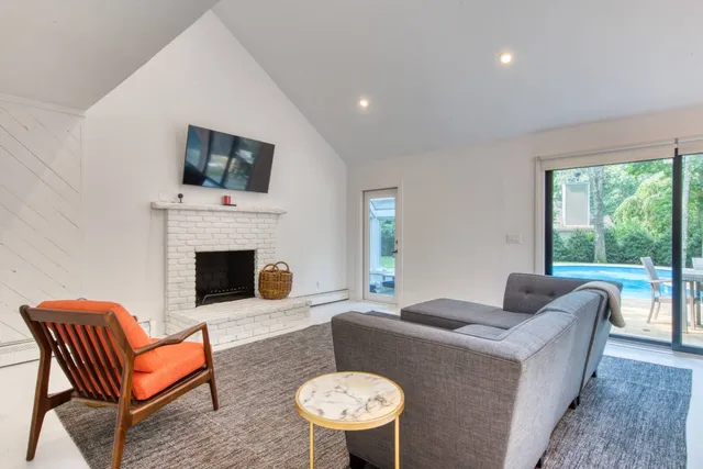 a living room with furniture a flat screen tv and a fireplace