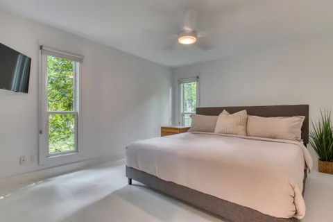 a large bed sitting in a bedroom next to a window