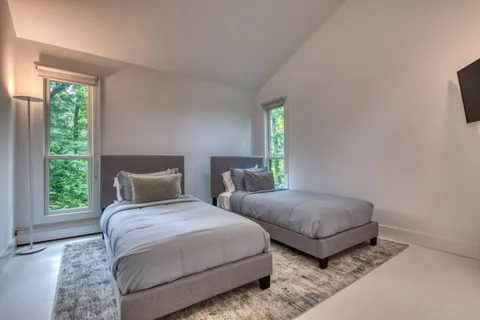 a bedroom with two beds and a window