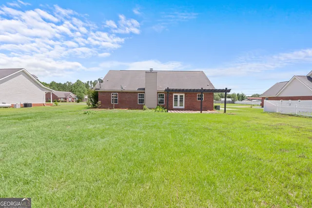 a view of a house with a big yard and large tree