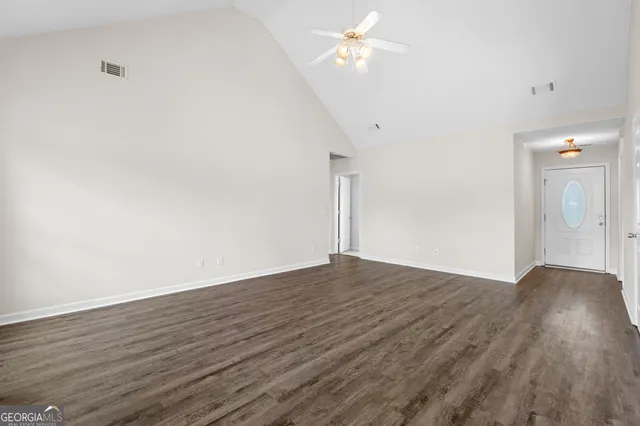 a view of empty room with wooden floor