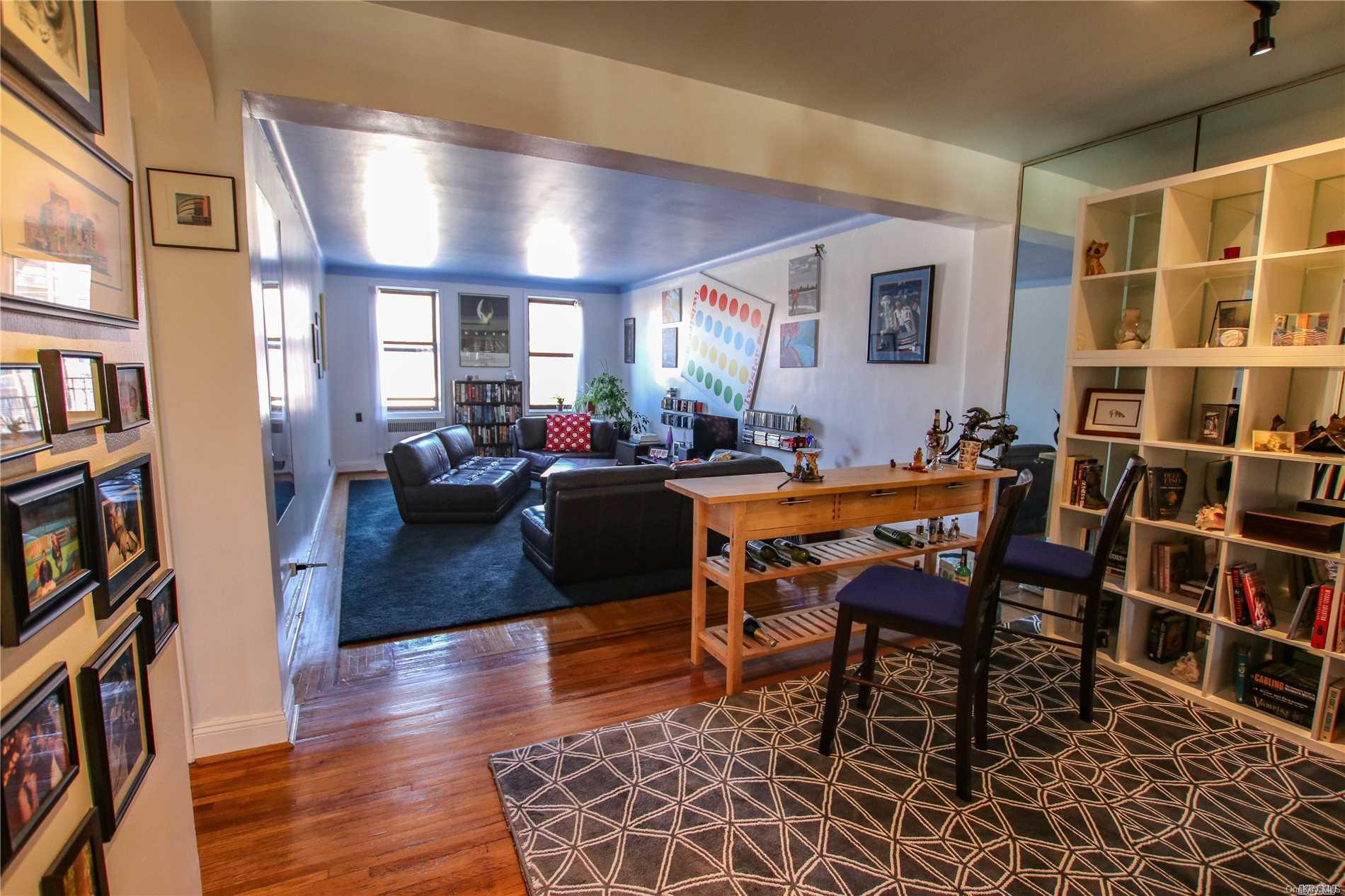 84-51 Beverly Road, Unit 3I Queens, NY 11415 - Photo 1 of 1 a living room with furniture a bookshelf and a wooden floor
