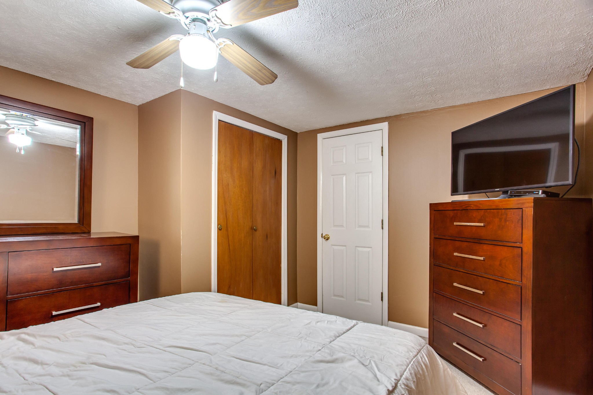 4332 Shipe Road Corryton, TN 37721 - Photo 16 of 25 a bedroom with a bed and a flat tv screen on dresser