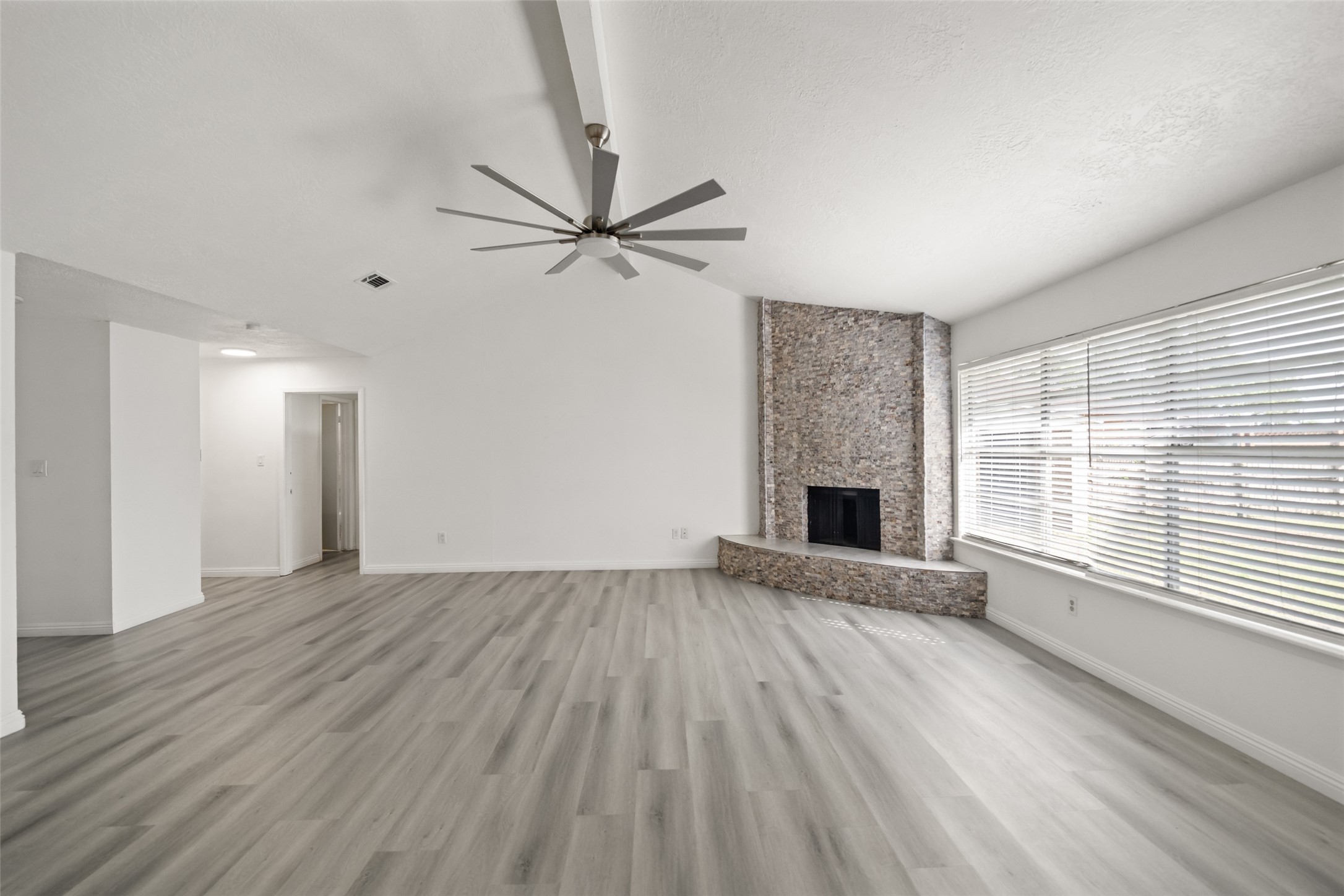 5726 Yorkgate Drive Spring, TX 77373 - Photo 7 of 20 an empty room with wooden floor a ceiling fan and windows