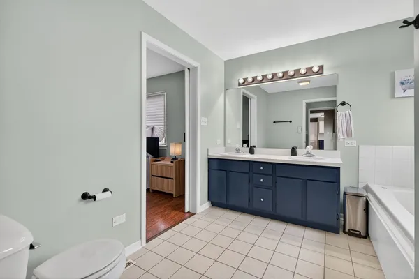 a bathroom with a tub a sink and mirror