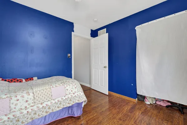 a bedroom with a bed and a bookshelf with wooden floor