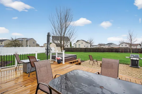 a view of a white house in front of a big yard with large trees