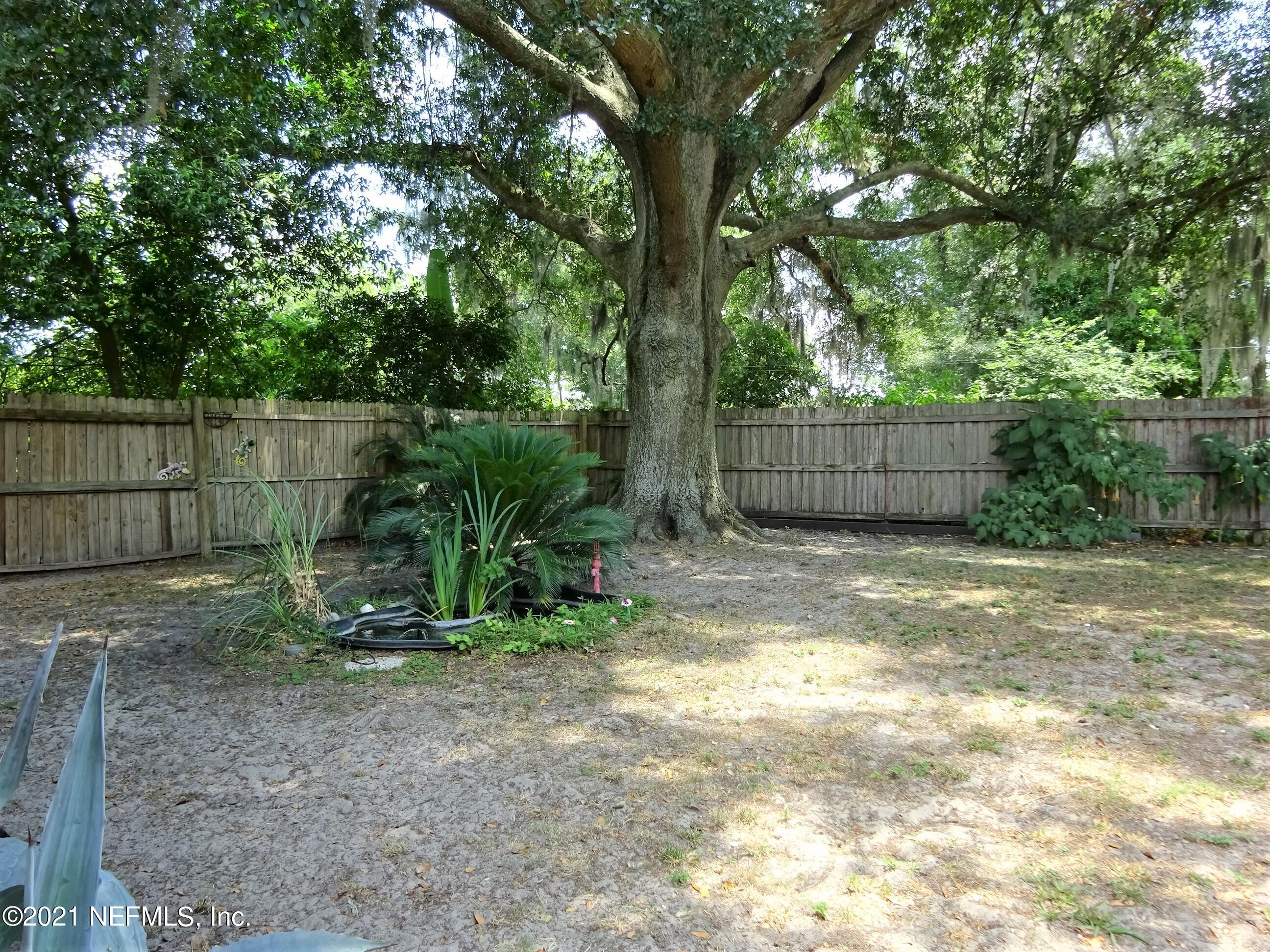 9347 Orme Road Jacksonville, FL 32220 - Photo 14 of 46 a view of a backyard with plants and large trees