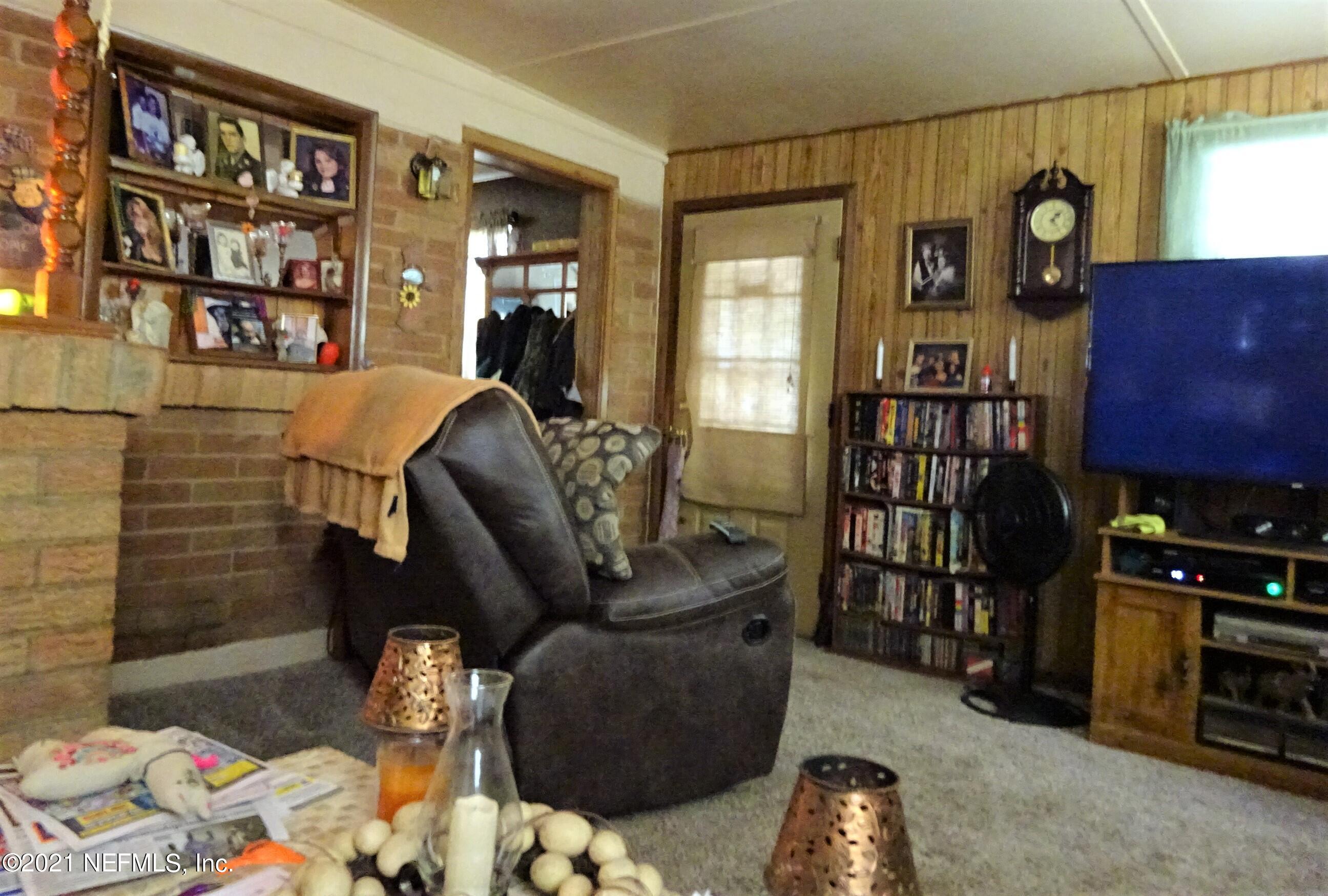 9347 Orme Road Jacksonville, FL 32220 - Photo 34 of 46 a living room with furniture a bookshelf and a window