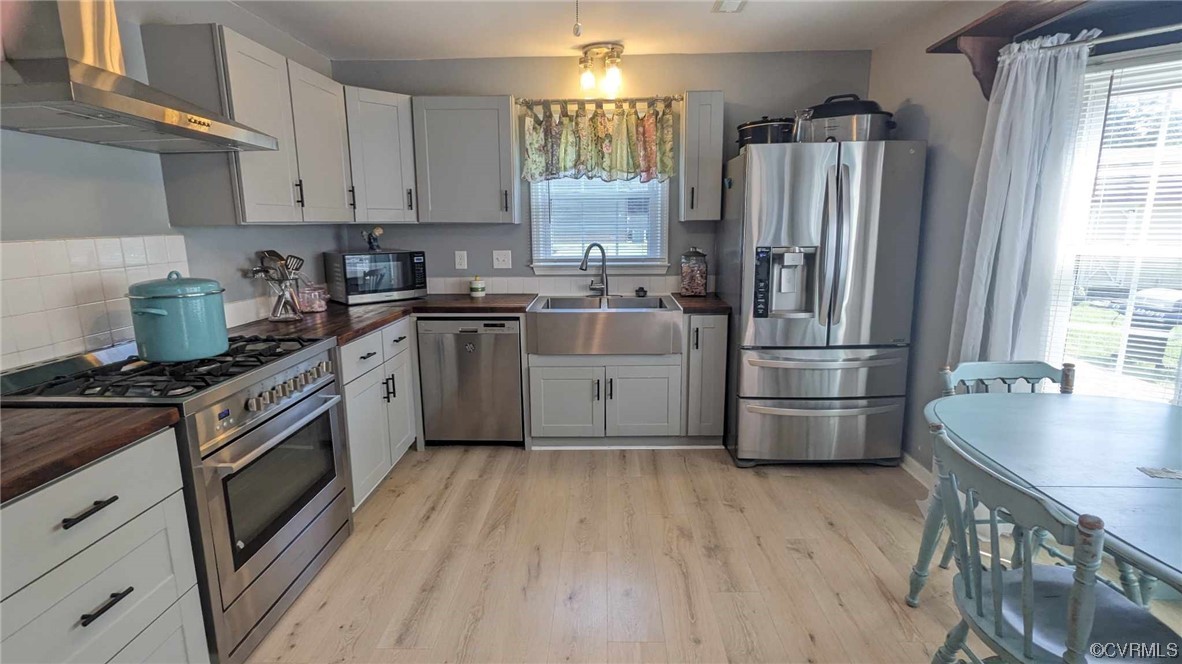 10770 Old Centralia Road Chester, VA 23831 - Photo 4 of 25 a kitchen with stainless steel appliances granite countertop a refrigerator a stove a sink dishwasher and white cabinets with wooden floor