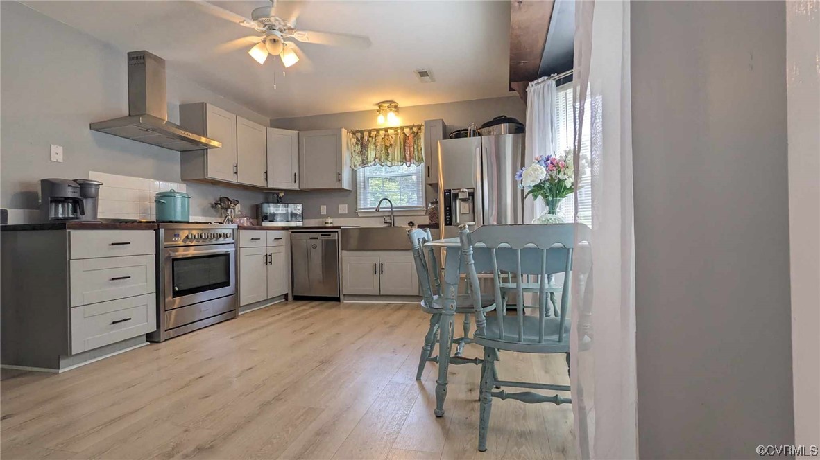 10770 Old Centralia Road Chester, VA 23831 - Photo 6 of 25 a kitchen with stainless steel appliances a stove a sink dishwasher a refrigerator and white cabinets with wooden floor