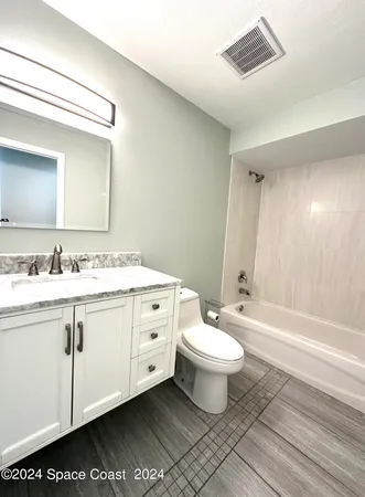 a bathroom with a double vanity sink mirror and toilet