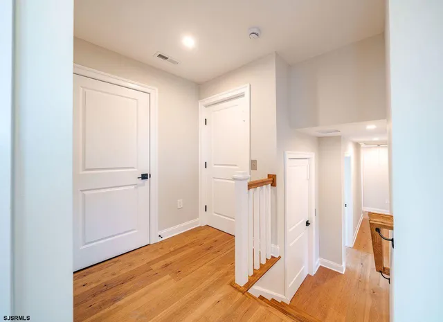 a view of a room with wooden floor and white walls