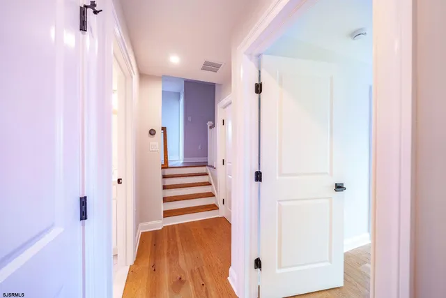a view of a hallway with wooden floor and staircase