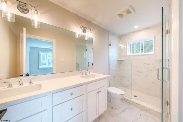 a bathroom with a sink a toilet and shower