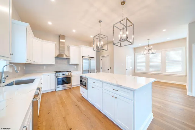 a large kitchen with granite countertop a sink a counter space appliances and cabinets
