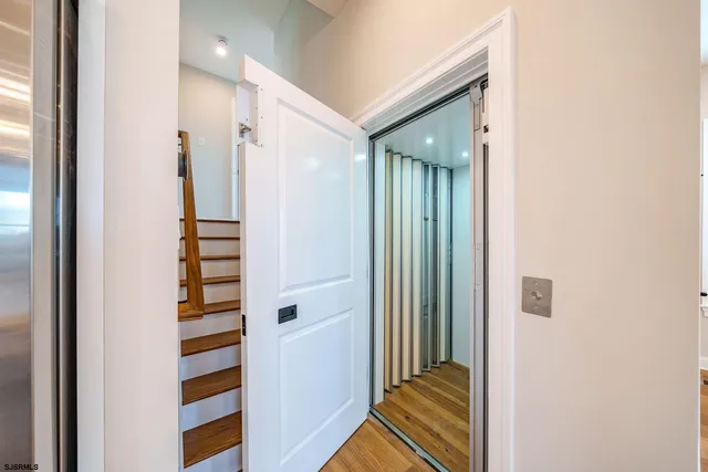 a view of a hallway with wooden floor and staircase