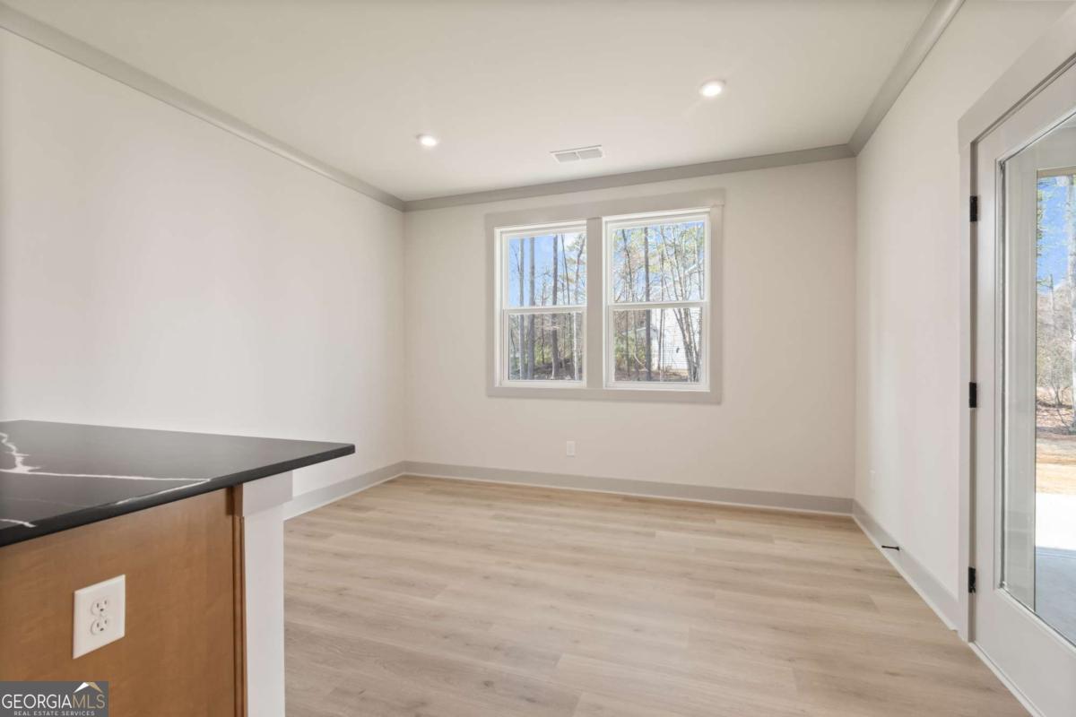 147 Henley Street, Unit 63 Canton, GA 30114 - Photo 14 of 36 a view of an empty room with wooden floor and a window