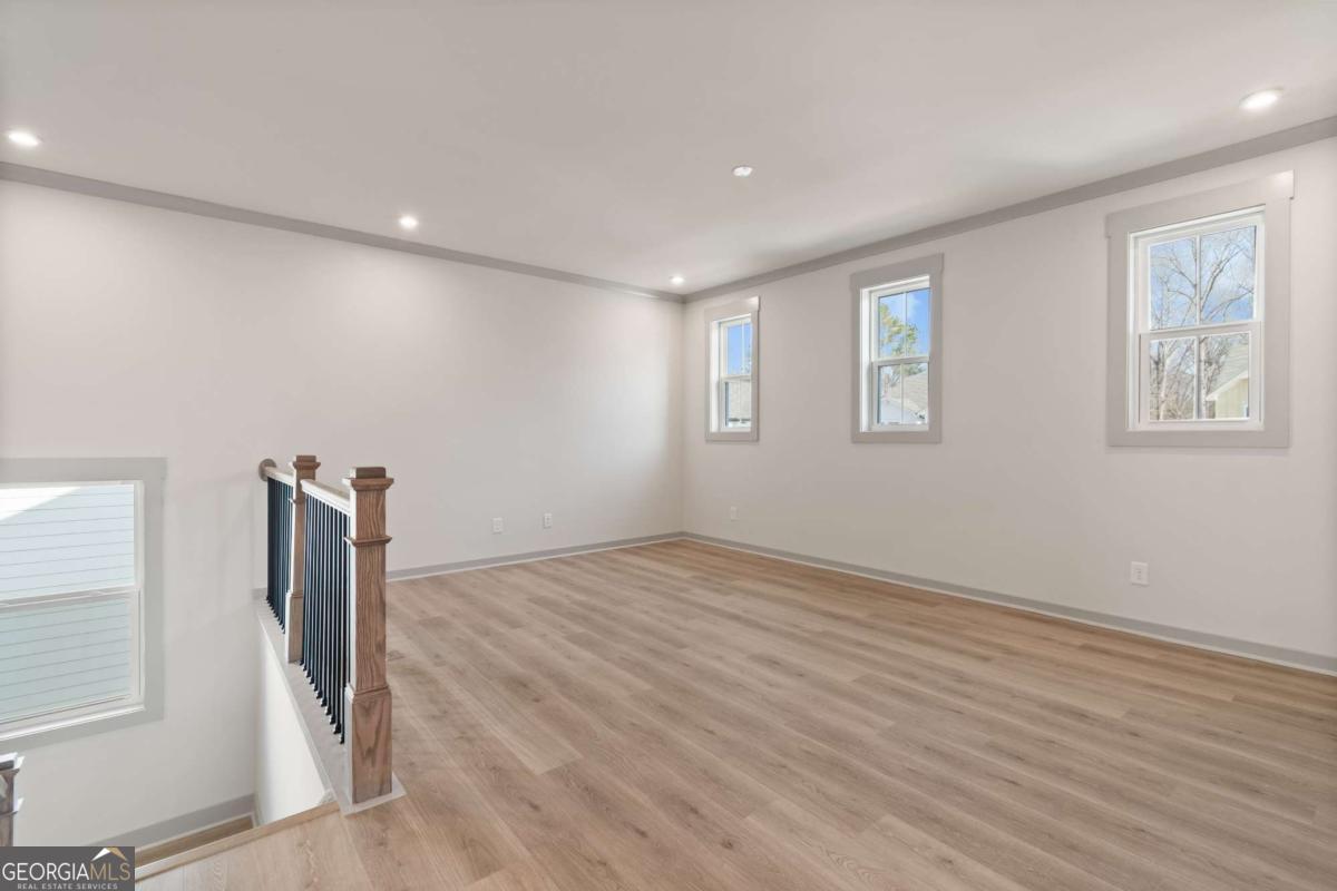 147 Henley Street, Unit 63 Canton, GA 30114 - Photo 22 of 36 a view of empty room with wooden floor and fan
