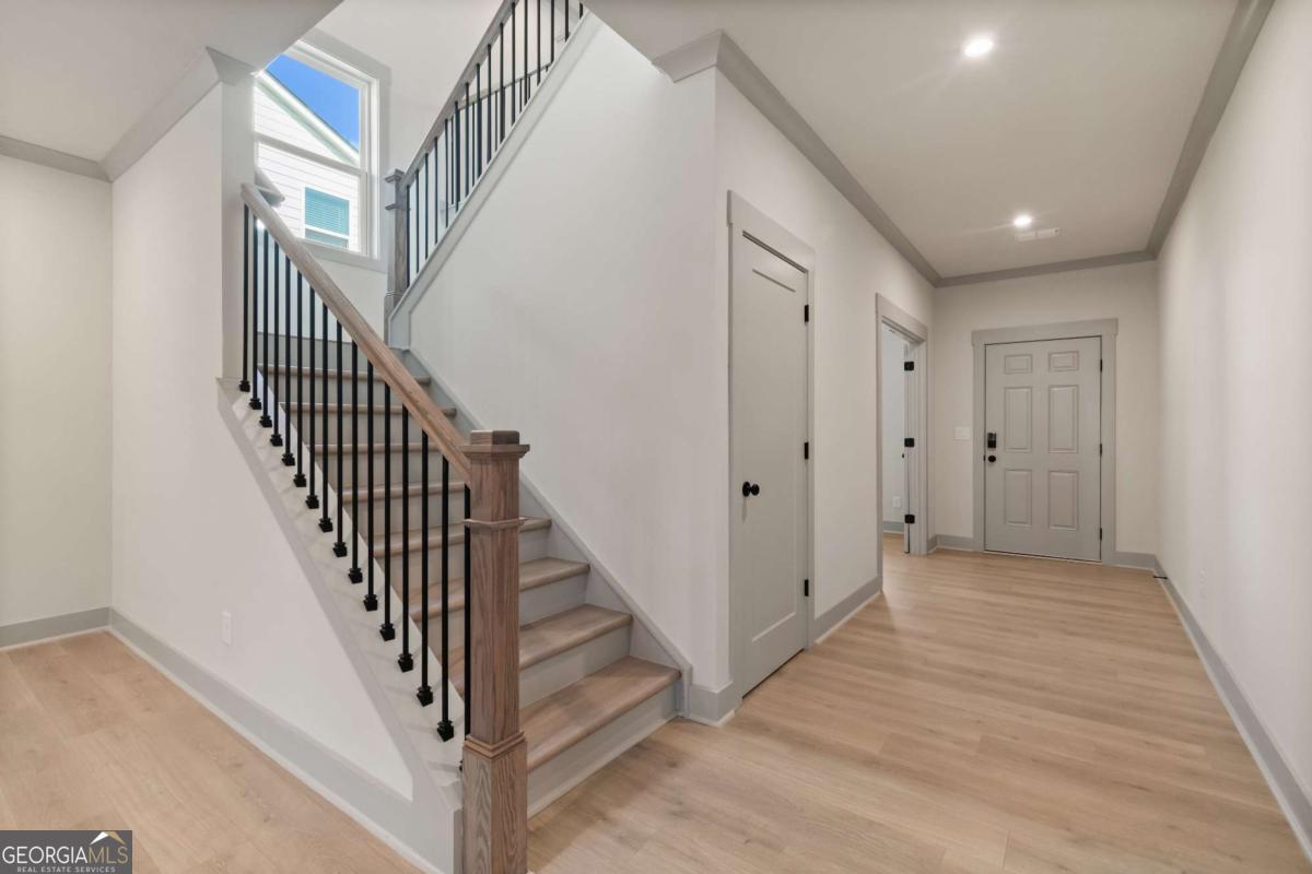 147 Henley Street, Unit 63 Canton, GA 30114 - Photo 6 of 36 a view of a hallway with wooden floor and staircase