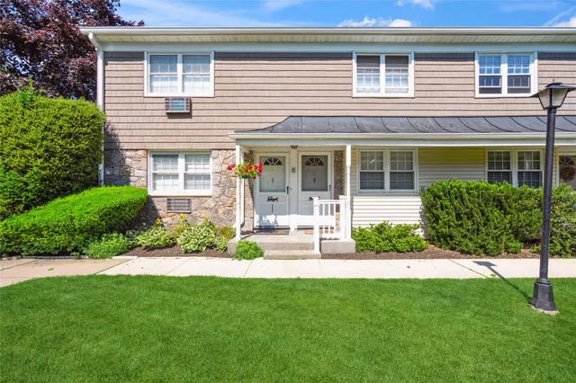 a front view of a house with a garden and plants