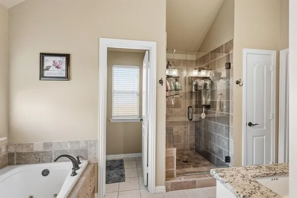 a spacious bedroom with a bed and a chandelier