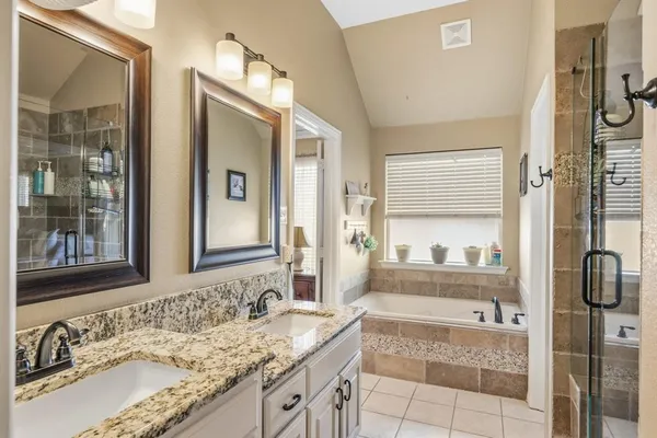 a en suite bathroom with a granite countertop sink and a mirror