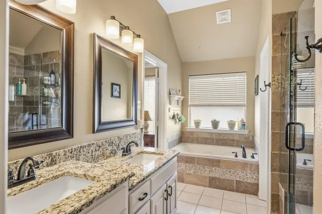 a en suite bathroom with a granite countertop sink and a mirror