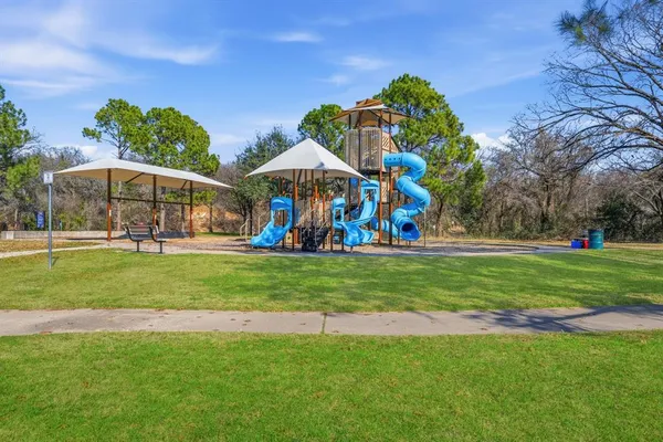 a view of a backyard with plants and wooden fence