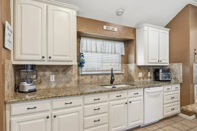 a large white kitchen with a stove a refrigerator a dining table and chairs