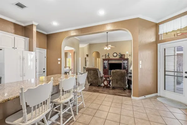 a kitchen with granite countertop a refrigerator stove and white cabinets